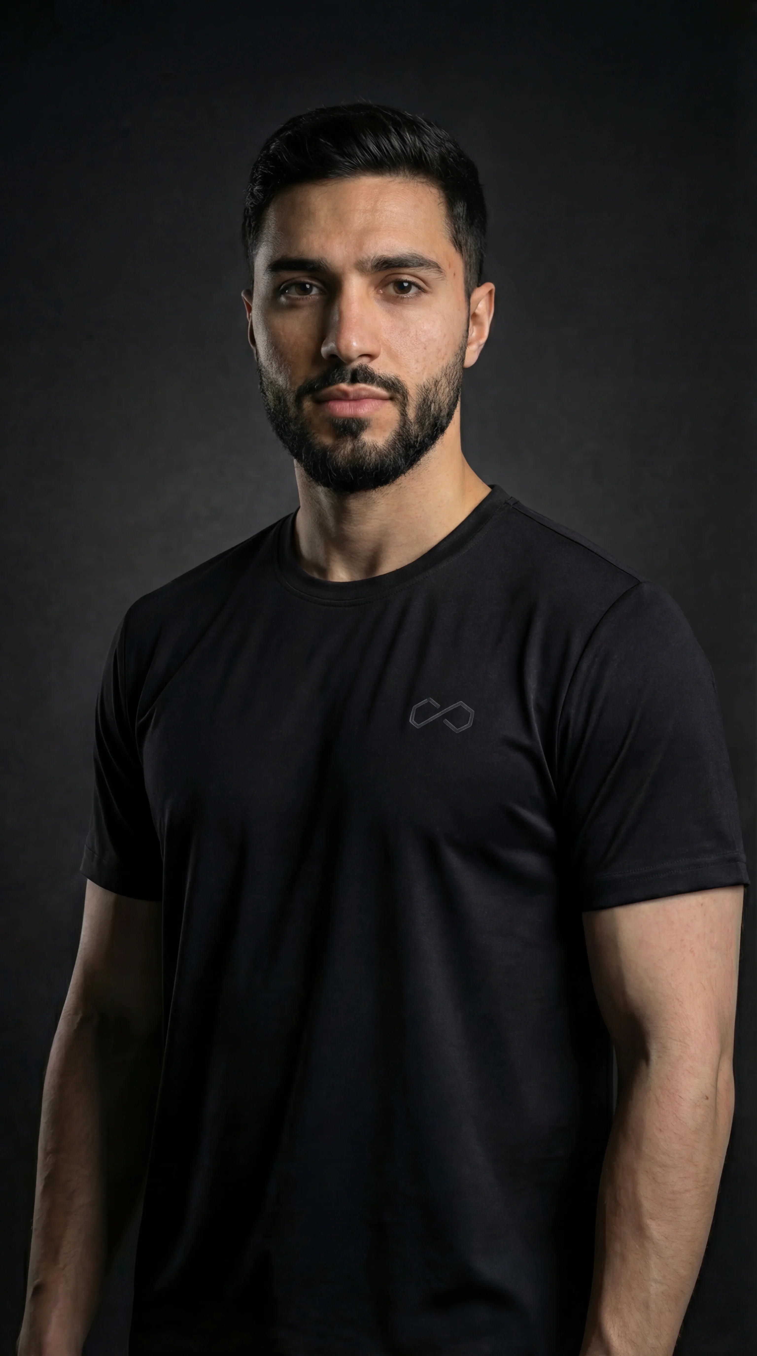 Homme portant un t-shirt noir minimaliste, logo discret, mode sport lifestyle.